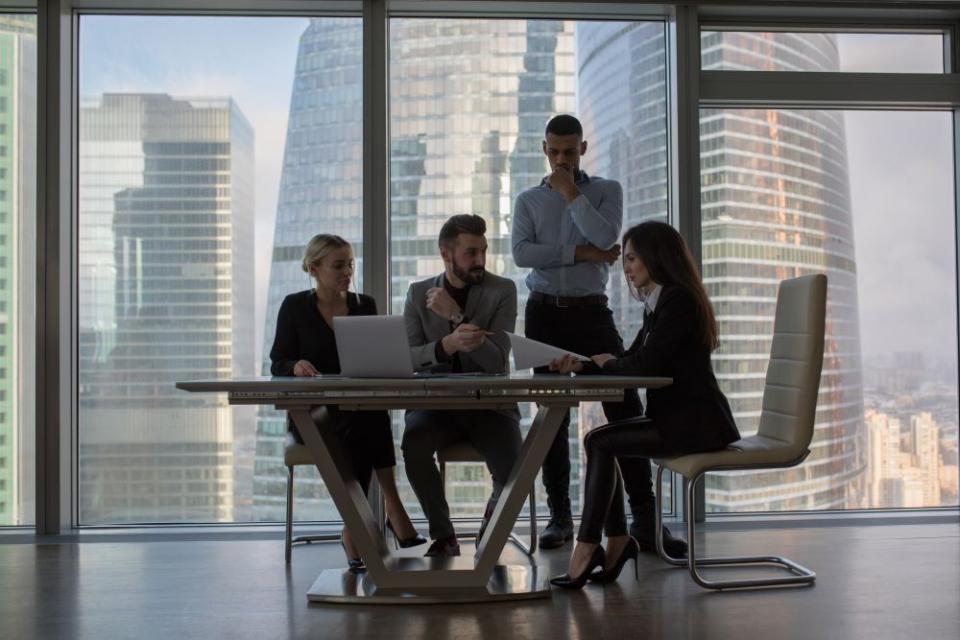 Business people working in an office on a background of panoramic windows Business people working in an office on a background of panoramic windows